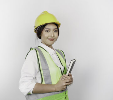 Smiling asian woman labor wearing safety helmet vest holding her book isolated by white background labor s day concept 360x320
